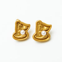 Gold earrings with a central pearl on a white background
